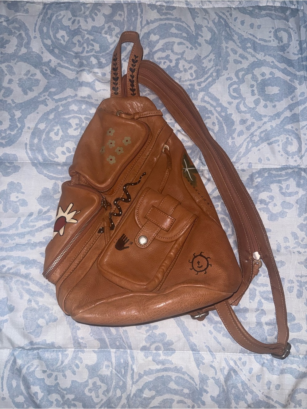 Compact Brown Leather Sling Backpack with Decorative Accents